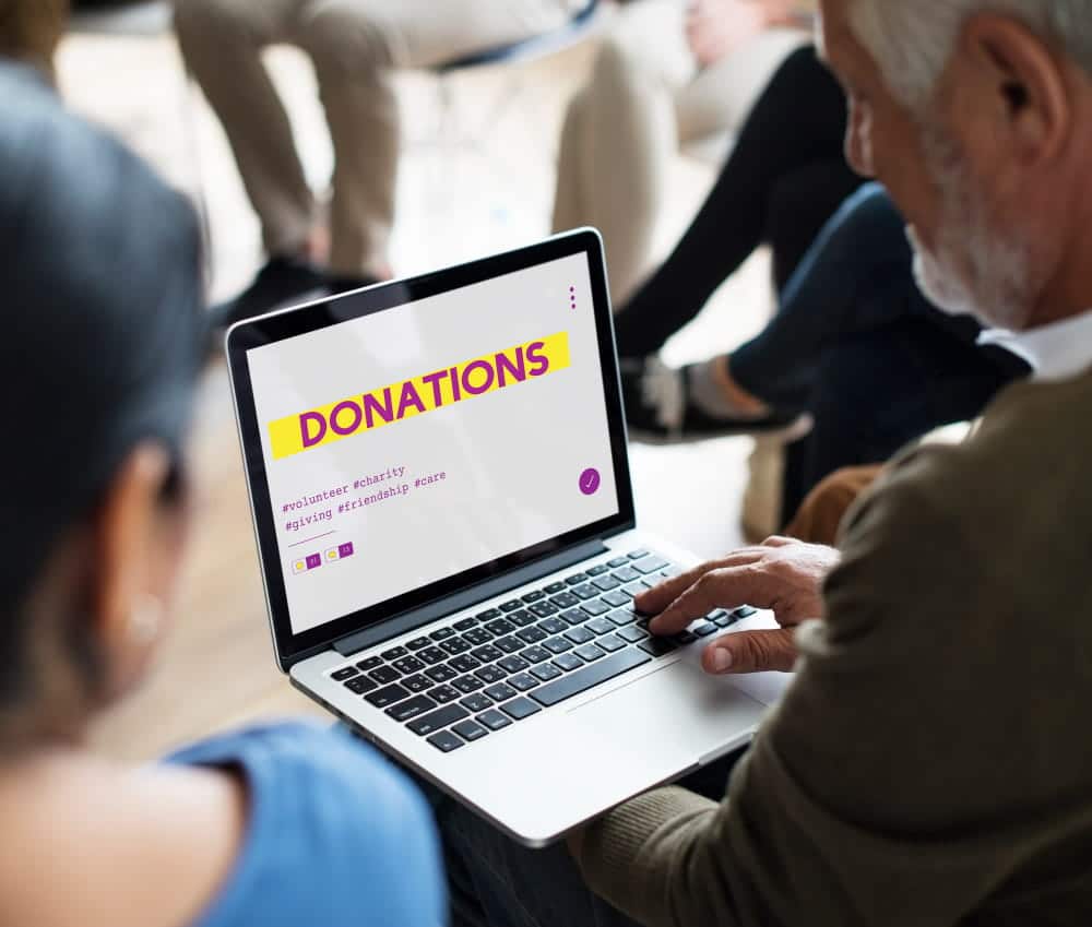 Charity finance team reviewing donation information on a laptop during a Xero migration